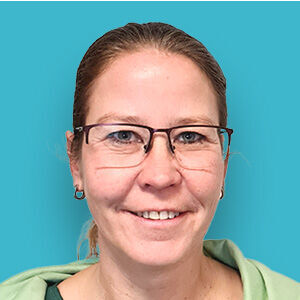 eine Frau mit Brille und einem grünen Hemd