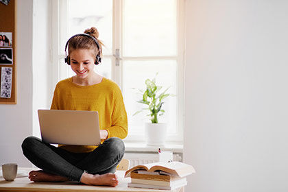 eine Frau sitzt auf einem Tisch mit einem Laptop