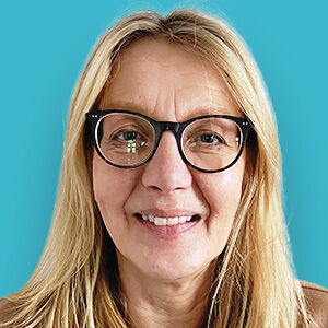 eine Frau mit Brille und blauem Hintergrund