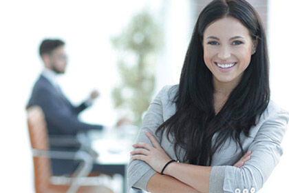 eine Frau, die mit verschränkten Armen die in einem Büro steht